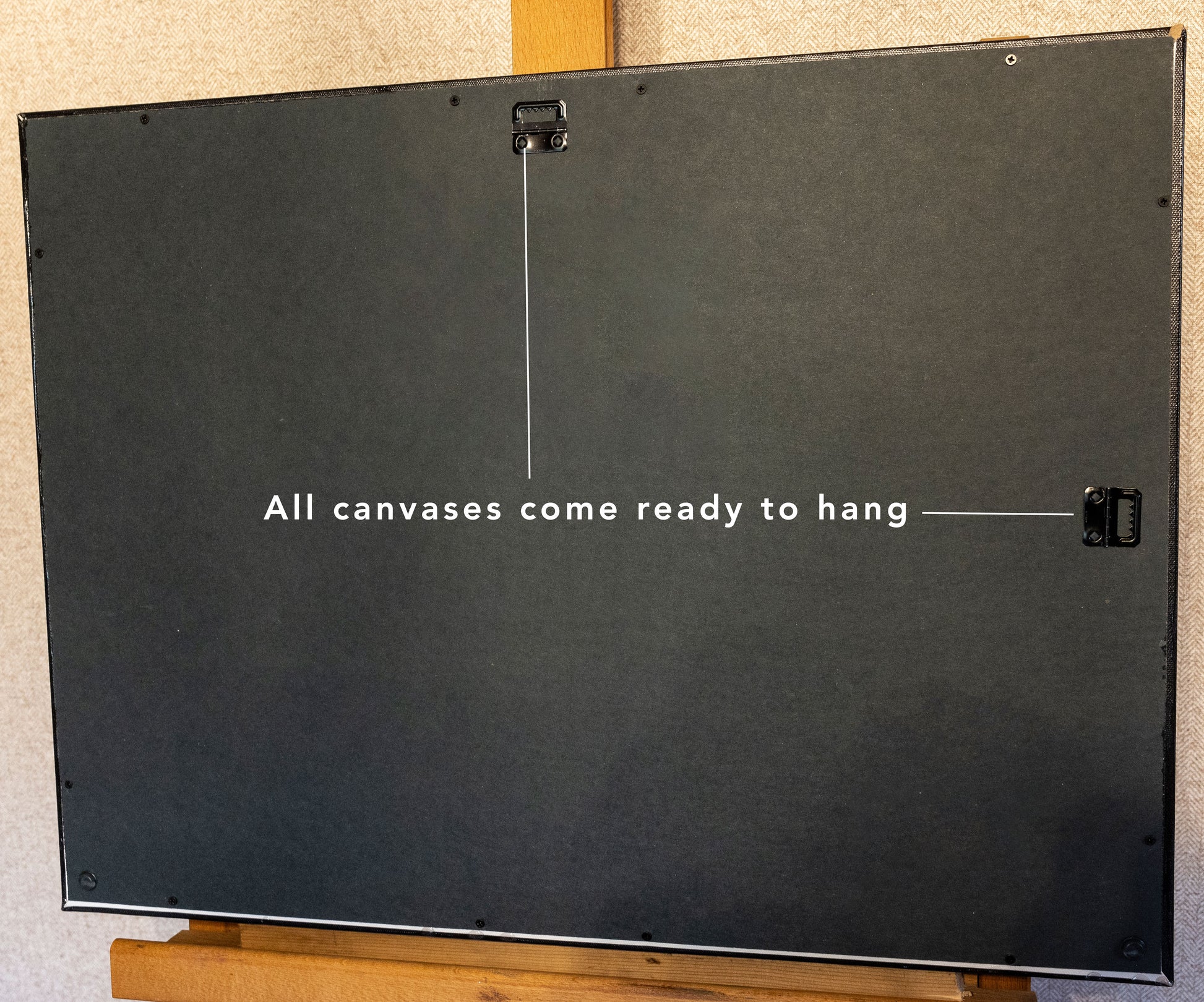 A photo of the back of the landscape canvas pointing to two hanging functions. Text reads, "All canvases come ready to hang."