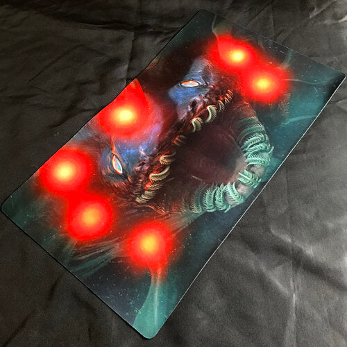 A full photo of the playmat. A fish with six bright red lights has its mouth open.