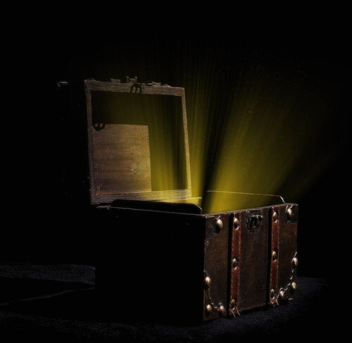 A dimly lit chest is open to reveal glowing yellow light within.